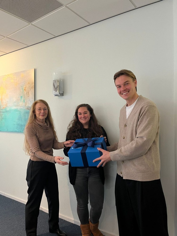 Drie mensen met een blauw Studdy-cadeau