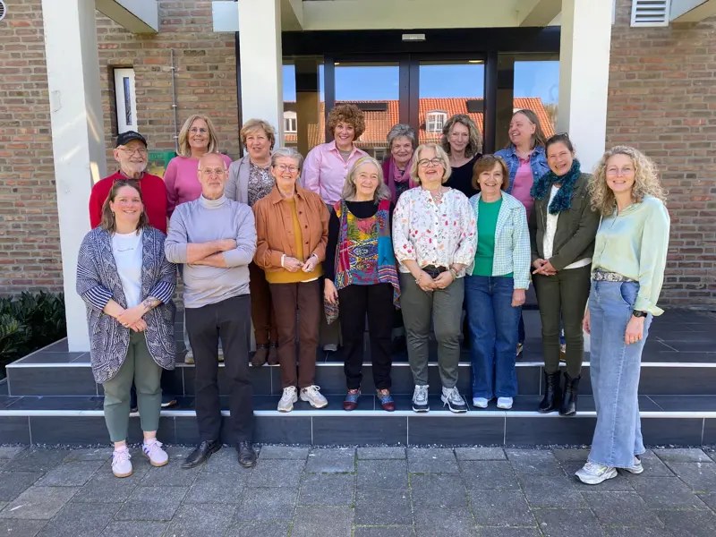 Een groep mensen samen voor een gebouw